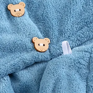 Gros plan sur le tissu épais en polaire corail bleu avec boutons en bois en forme d'ours