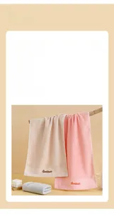 Detail view of cotton towel texture featuring embroidered Goodliness letters on the border