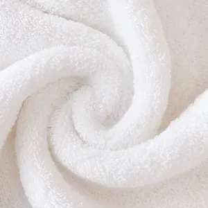 Macro shot of white Xinjiang long-staple cotton towel showing soft thick looped texture