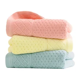 Three-piece set of premium absorbent cotton towels in soft pink, yellow, and blue colors