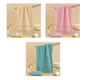 Detail view of cotton towels in beige, pink and green with soft terry texture