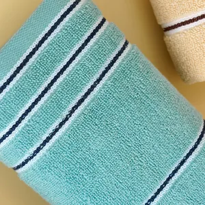 Thick mint green and beige cotton towels with striped texture and soft looped pile