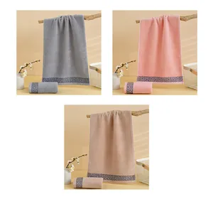 Detail of soft cotton towels with Greek key pattern in grey, pink, and beige tones