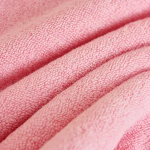 Pink cotton towel showing thick absorbent terry loops and soft fluffy texture