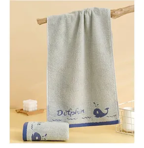Détail d'une serviette en coton gris avec broderie baleine bleue et texte Dolphin