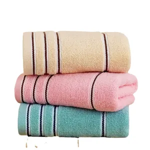 Thick cotton towels set in beige, pink, and blue with striped texture for bathroom
