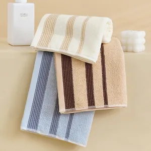 Trois serviettes en coton à rayures crème, bleu et marron avec texture absorbante