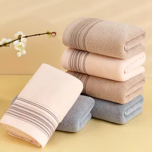 Pila de toallas de algodón absorbente en beige y azul con suave textura a rayas