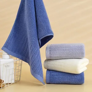 Primo piano di asciugamani in cotone spesso e assorbente in blu, viola e beige