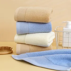 Dettaglio di asciugamani in cotone morbido kaki e blu con eleganti bordi a righe