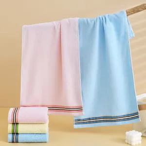 Three absorbent cotton towels in pink, blue and yellow with striped edge detail