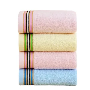 Set of four soft absorbent cotton towels in pink yellow and blue with striped detail