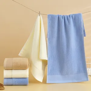 Dettaglio di asciugamani in cotone morbido blu, giallo e marrone con bordo a righe testurizzato