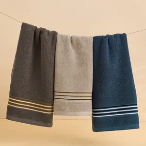 Trois serviettes en coton de qualité en gris beige et bleu marine à rayures élégantes