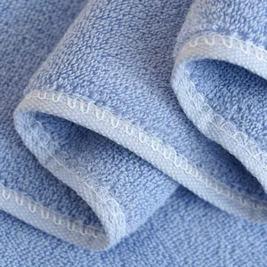 Dettaglio ravvicinato della trama di asciugamano in cotone azzurro con bordi rifiniti