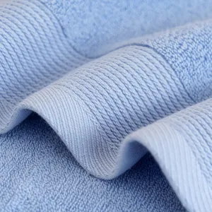 Macro dettaglio di un asciugamano in cotone azzurro con morbide spugne e trama a costine