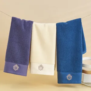Dettaglio di asciugamani in cotone per hotel con logo a corona ricamato di lusso