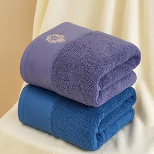 Dettaglio di asciugamani in cotone premium con elegante ricamo dorato a forma di corona