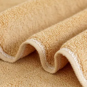 Dettaglio macro dell'asciugamano di cotone kaki con riccioli assorbenti e cuciture bianche rinforzate