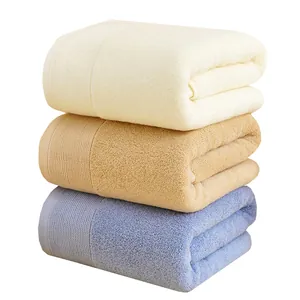 Set di tre asciugamani da bagno spessi in cotone assorbente nei colori crema, marrone e blu