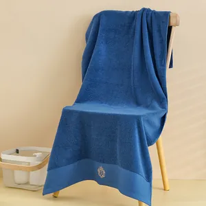 Dettaglio macro di asciugamano in cotone blu scuro con ricamo logo corona di lusso