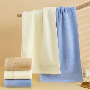 Set di asciugamani in cotone spesso color crema, azzurro e beige su supporto in legno