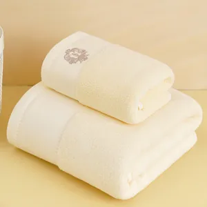 Dettaglio del set di asciugamani in cotone beige con elegante ricamo marrone scuro