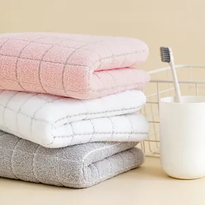 Detailed view of stacked waffle texture cotton towels in pink white and grey colors