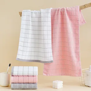 Detail of soft thick cotton towels with checkered texture in white, pink and gray tones