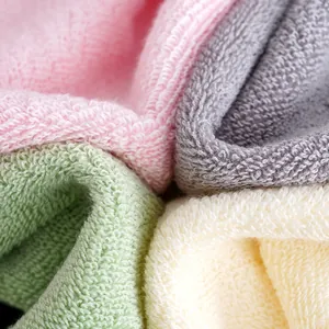 Close-up of thick absorbent cotton towels in pink grey green and beige with plush texture