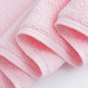 Macro detail of pink absorbent cotton towel with soft texture and durable stitched edges