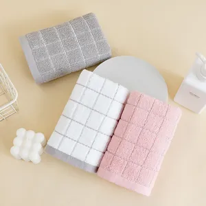 Three-piece set of cotton towels in pink, white, and gray with waffle weave texture