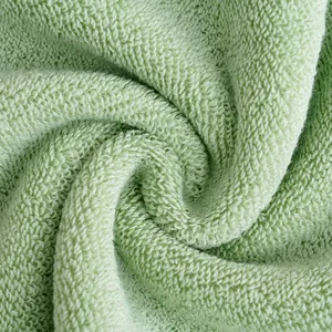 Macro detail of high-density light green cotton towel with spiral loop texture