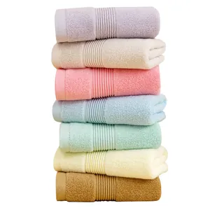 Set of seven absorbent thick cotton towels in assorted soft pastel colors stacked neatly