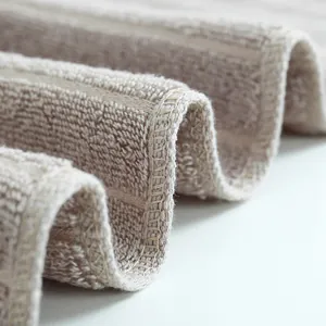 Asciugamano in cotone marrone chiaro spesso con morbida texture e bordi cuciti