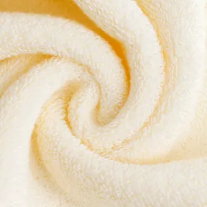 Thick cream-colored cotton towel with soft looped texture in a spiral display