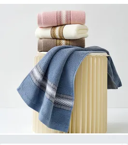 Détail de serviettes en coton empilées avec rayures jacquard et texture éponge