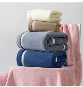 Detailed view of stacked thick coral fleece towels showing soft texture and hemmed edges