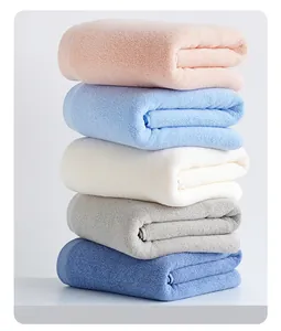 Close-up of five colorful folded thick cotton bath towels with soft plush loop texture
