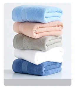 Close-up of neatly stacked plush cotton bath towels showing soft looped pile texture