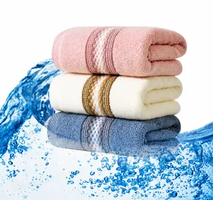 Macro shot of three stacked soft cotton towels in pink white and blue with absorbent texture