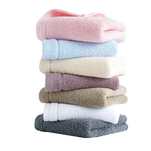 Vertical stack of seven colorful thick cotton towels with soft fluffy texture and neat edges