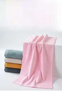 Close-up of geometric textured cotton towels in pink, teal, cream, and yellow colors