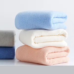 Stack of absorbent thickened cotton towels in various solid colors for home and hotel use