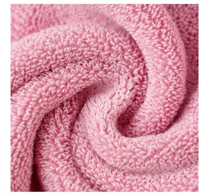 Macro shot of thick pink cotton towel showing soft loop texture and fluffy fabric