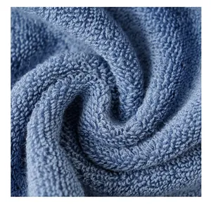 Gros plan d'une serviette en coton bleu avec texture bouclée dense et tissu très doux