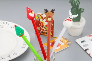 Close-up of Christmas gel pen set with Santa, reindeer, and tree toppers in a glass jar