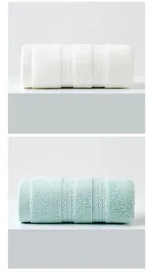 Close-up of rolled white and mint green thick cotton towels with soft absorbent texture
