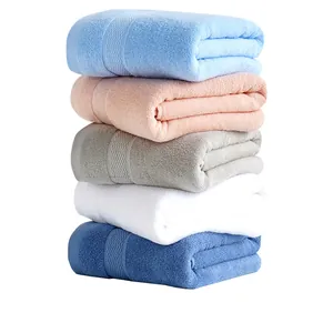 Stack of thick absorbent cotton bath towels in blue, pink, grey and white colors
