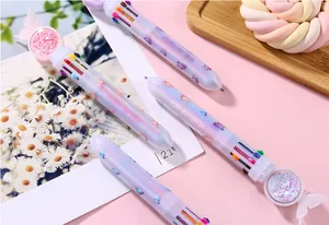 Dettaglio di penna a sfera multicolore con farfalla e decorazione a sfera glitterata